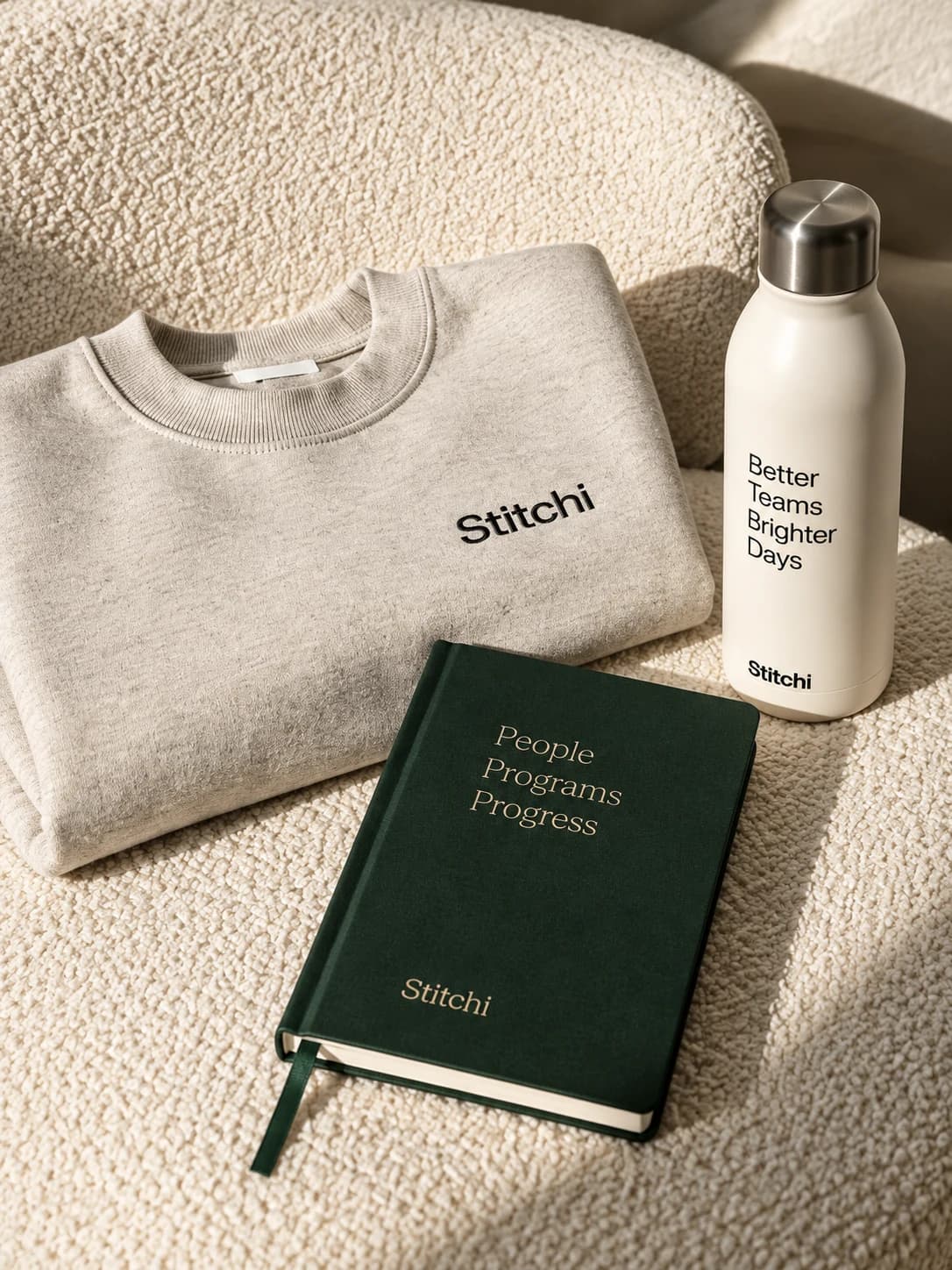 Stitchi employee program apparel, drinkware, and notebook
